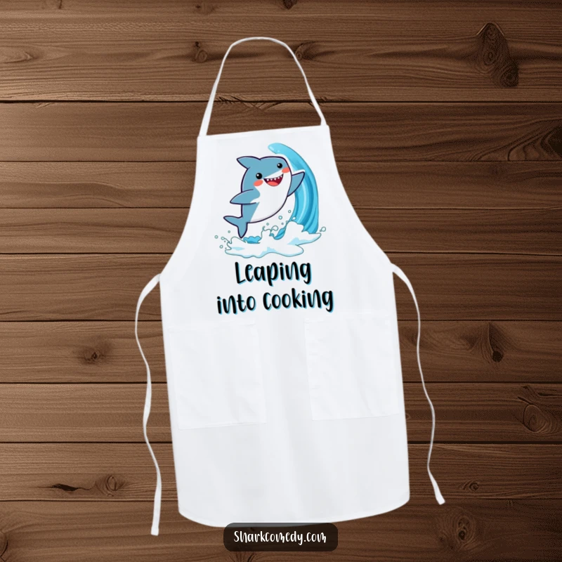 Funny apron showcasing a cute, kawaii shark leaping from a blue wave, designed for kitchen use and adding playful energy.