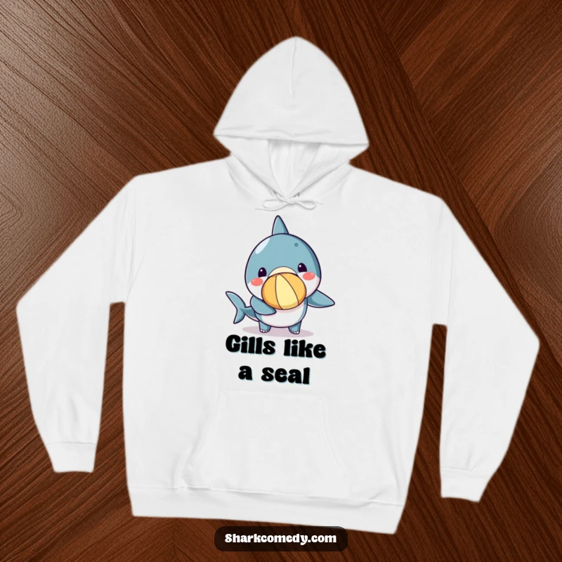 Funny kawaii shark hoodie showing a cute shark concentrating hard while balancing a bright beach ball on its nose.