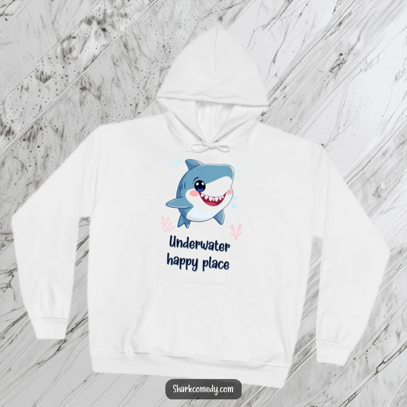 Funny smiling shark character, blowing bubbles underwater with wide, happy eyes, featured on a warm and cozy hoodie.